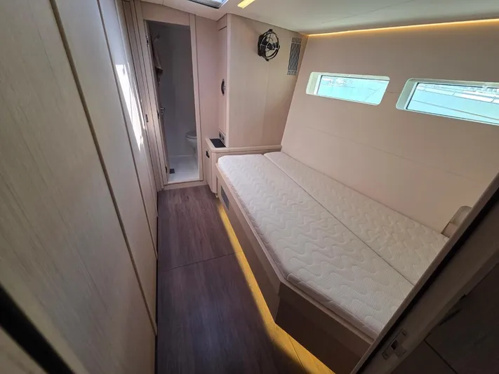 Yachting Conseil Yacht Photos Pics 2023 Jeanneau 60 yacht interior cabin with bed, windows, and modern design.