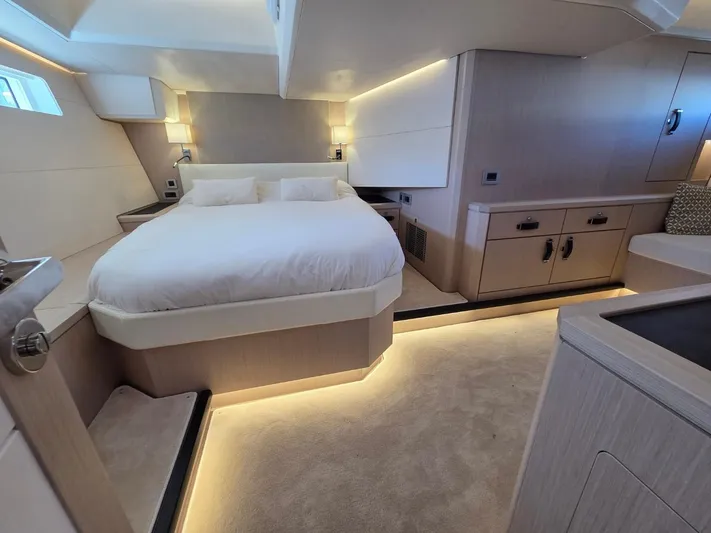 Yachting Conseil Yacht Photos Pics Luxurious interior of 2023 Jeanneau 60 yacht with modern bedroom design and ambient lighting.