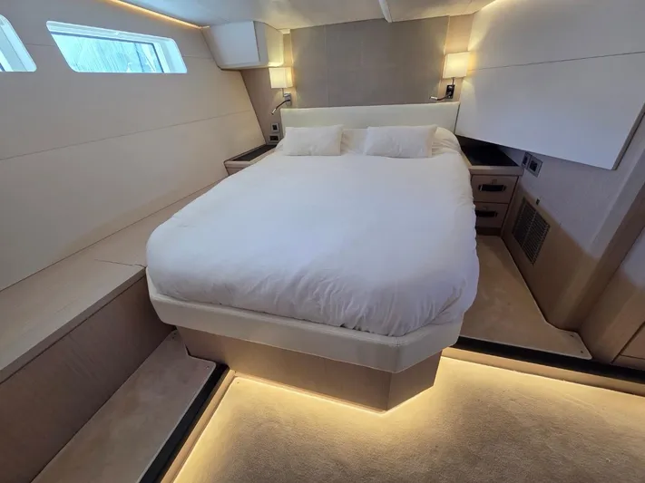 Yachting Conseil Yacht Photos Pics Luxurious bedroom interior of 2023 Jeanneau 60 yacht with modern lighting and elegant design.