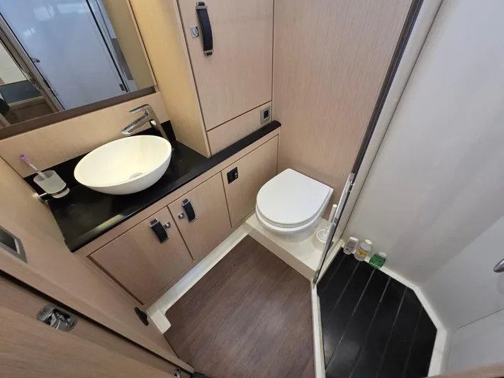 Yachting Conseil Yacht Photos Pics Modern bathroom in 2023 Jeanneau 60 yacht with sleek fixtures and wood accents.