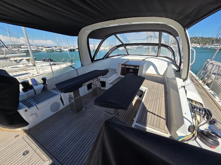 Yachting Conseil Yacht Photos Pics 2023 Jeanneau 60 yacht cockpit with seating, docked in a marina.