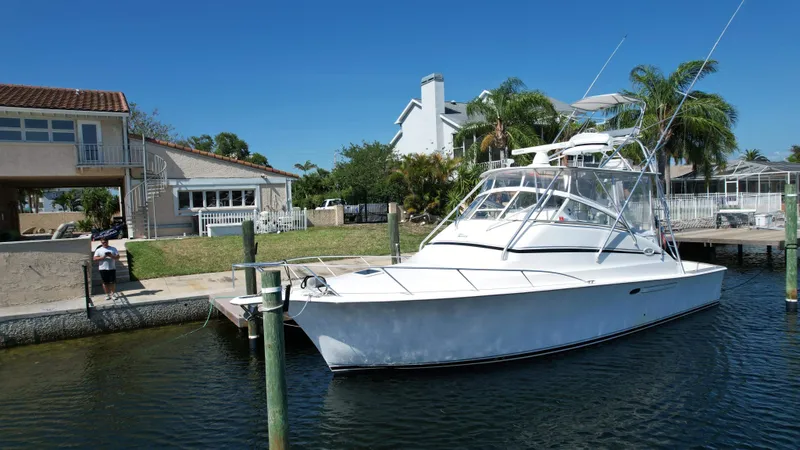 The Boo Factor Yacht Photos Pics 2003 Ocean 40 Super Sport yacht docked near waterfront homes, clear blue sky.
