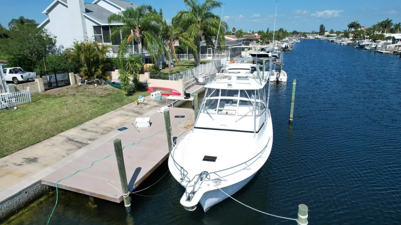 The Boo Factor Yacht Photos Pics 2003 Ocean 40 Super Sport yacht docked in a scenic canal with palm trees.