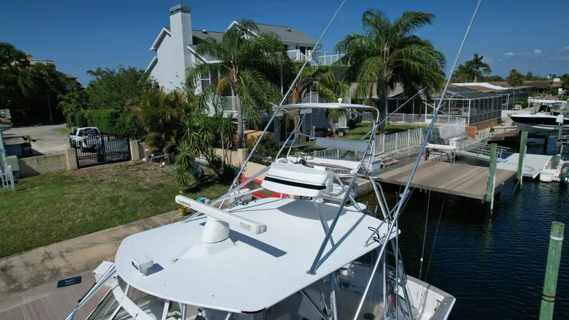 The Boo Factor Yacht Photos Pics 2003 Ocean 40 Super Sport yacht docked near waterfront homes with palm trees.