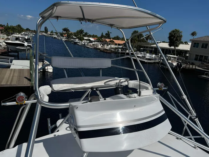 The Boo Factor Yacht Photos Pics 2003 Ocean 40 Super Sport yacht helm with marina view, clear sky, and waterfront homes.