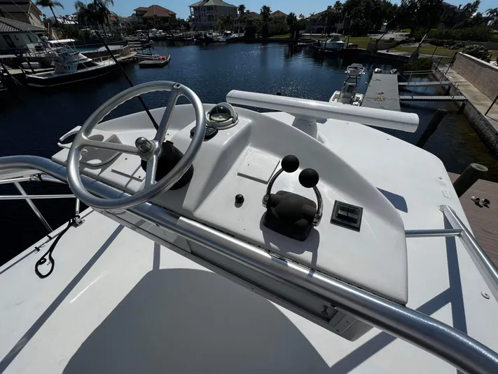 The Boo Factor Yacht Photos Pics 2003 Ocean 40 Super Sport yacht helm with steering wheel and controls, docked in a marina.