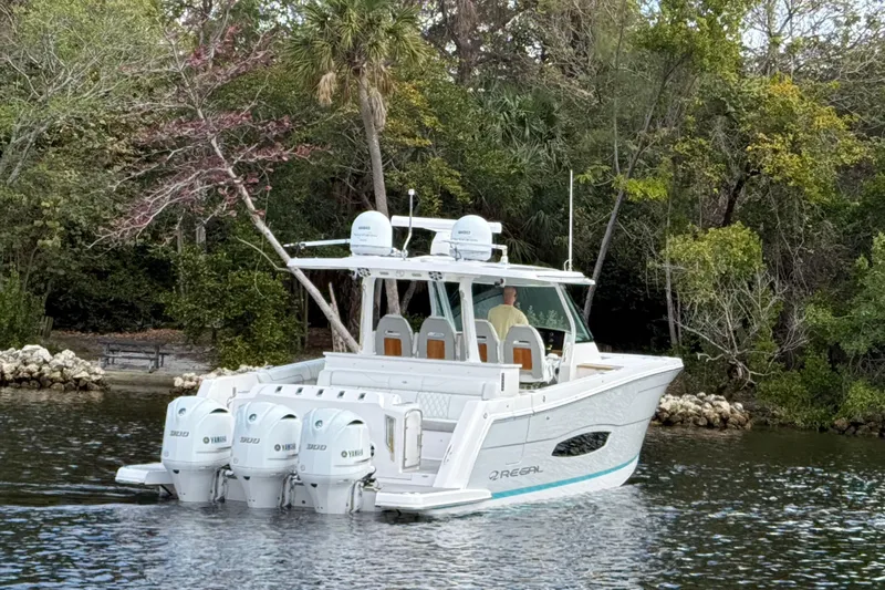  Yacht Photos Pics 2020 Regal 38 SAV boat cruising on a serene waterway surrounded by lush greenery.