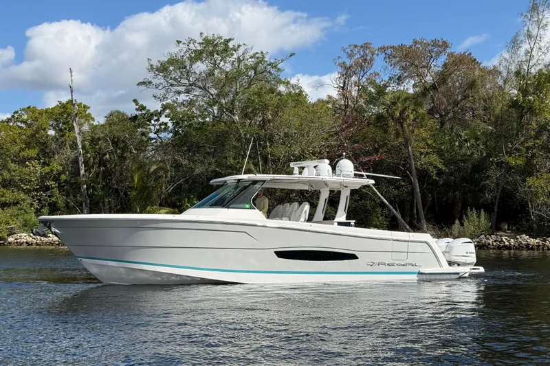  Yacht Photos Pics 2020 Regal 38 SAV boat cruising on a calm river with lush greenery background.