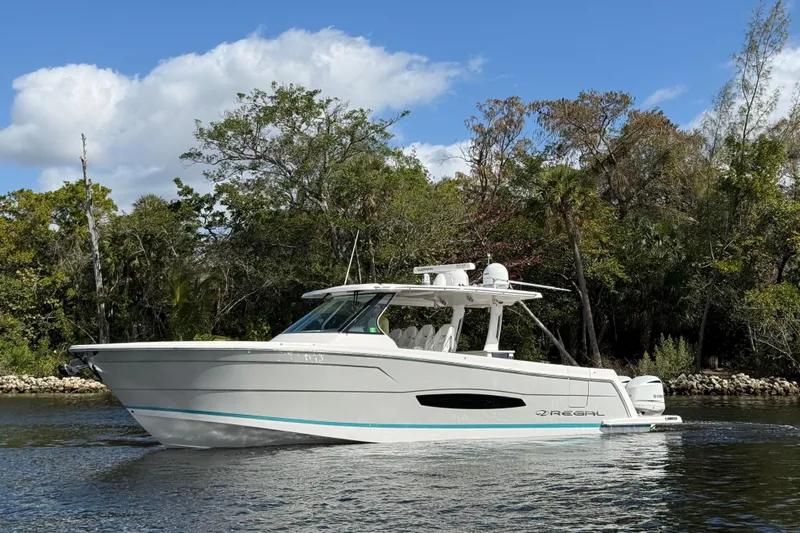  Yacht Photos Pics 2020 Regal 38 SAV boat cruising on a scenic river with lush greenery.