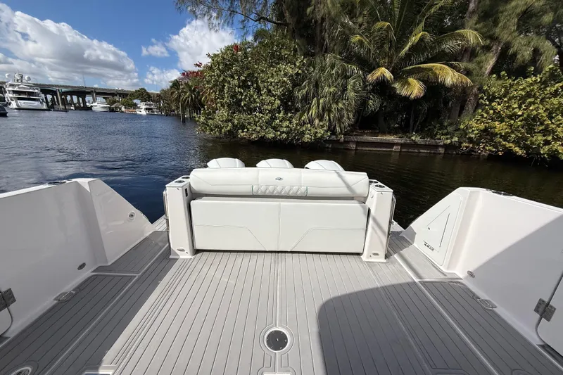  Yacht Photos Pics 2020 Regal 38 SAV boat deck with seating, surrounded by lush greenery and waterway.