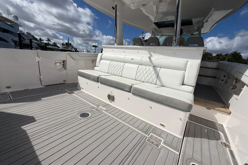  Yacht Photos Pics 2020 Regal 38 SAV boat deck with cushioned seating under a cloudy sky.