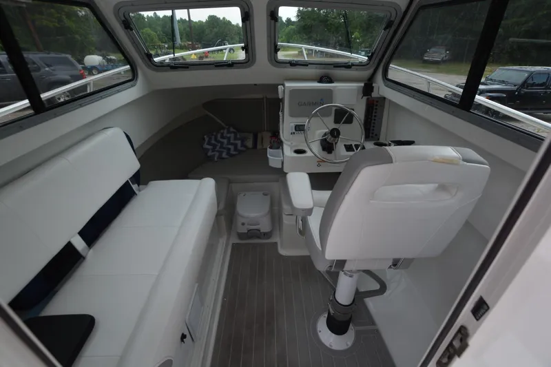 Still Yacht Photos Pics Interior of a 2025 Parker 2420 boat with seating and steering console.