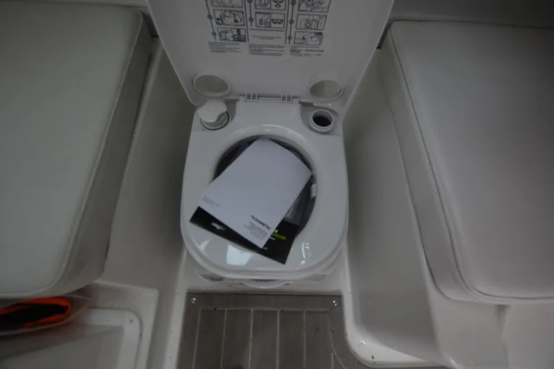 Still Yacht Photos Pics Boat toilet with open lid, Parker 2420 model, 2025, featuring instruction manuals inside.