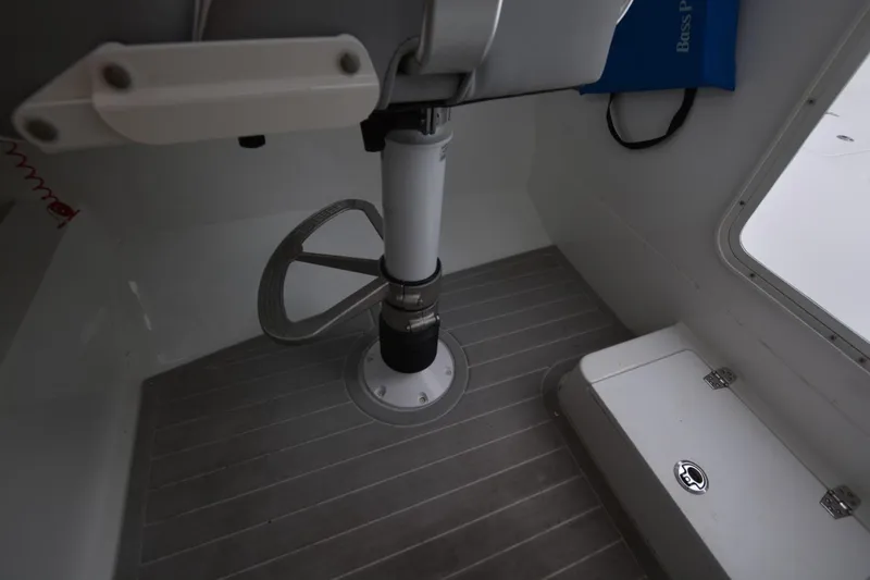 Still Yacht Photos Pics Interior of a 2025 Parker 2420 boat, featuring a steering wheel and storage compartment.