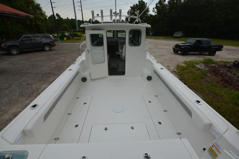 Still Yacht Photos Pics 2025 Parker 2420 boat with spacious deck, parked outdoors.