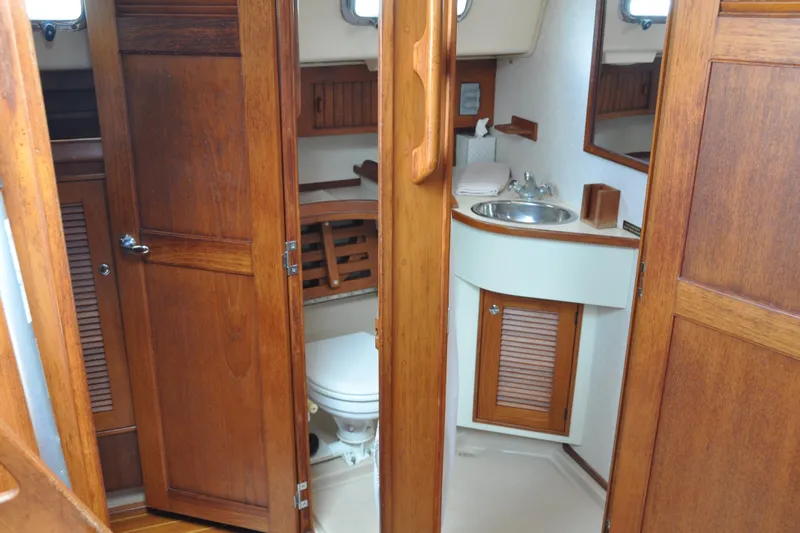 Resolute Yacht Photos Pics 2002 Island Packet 420 yacht bathroom with wooden cabinetry and compact sink.