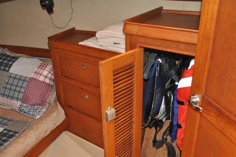 Resolute Yacht Photos Pics Cozy cabin interior of 2002 Island Packet 420 sailboat with wooden storage and bedding.