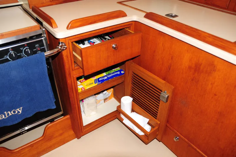 Resolute Yacht Photos Pics 2002 Island Packet 420 yacht kitchen with wooden cabinetry and storage compartments.