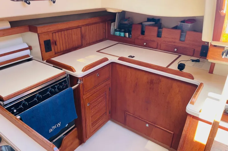 Resolute Yacht Photos Pics 2002 Island Packet 420 yacht kitchen with wooden cabinetry and modern appliances.