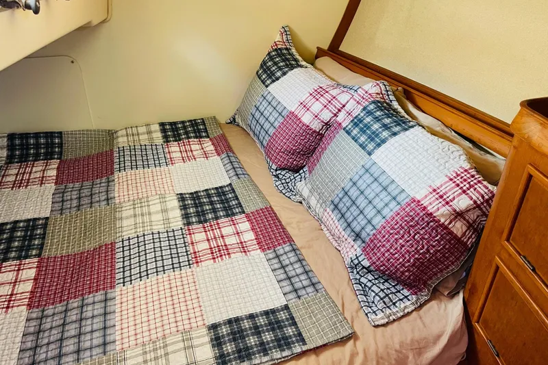 Resolute Yacht Photos Pics Cozy cabin bed with patchwork quilt on 2002 Island Packet 420 sailboat.