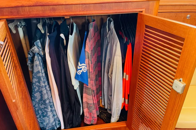 Resolute Yacht Photos Pics Clothes neatly hanging in a wooden closet on a 2002 Island Packet 420 yacht.
