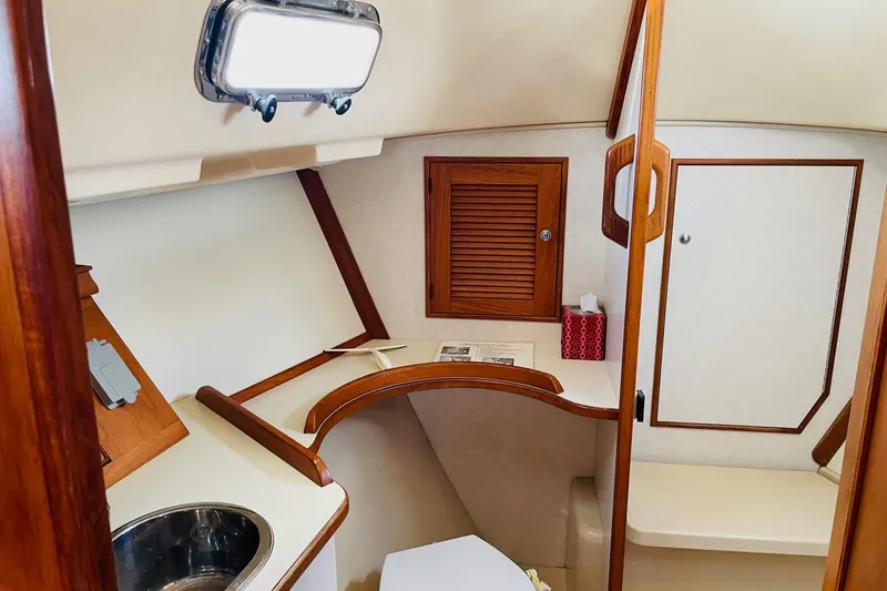 Resolute Yacht Photos Pics 2002 Island Packet 420 yacht interior with wooden cabinetry and compact bathroom.
