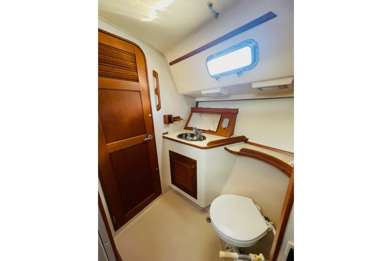 Resolute Yacht Photos Pics 2002 Island Packet 420 yacht bathroom with wooden accents and compact design.