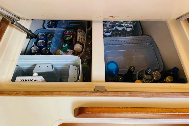 Resolute Yacht Photos Pics Storage compartment on 2002 Island Packet 420 yacht, stocked with beverages and condiments.