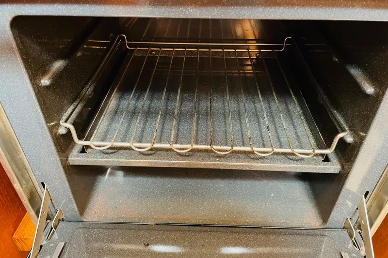 Resolute Yacht Photos Pics Empty oven interior with metal rack, viewed from the front.