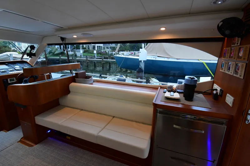 Promesa Yacht Photos Pics Interior of 2021 Hylas M44 yacht with seating, kitchenette, and marina view.