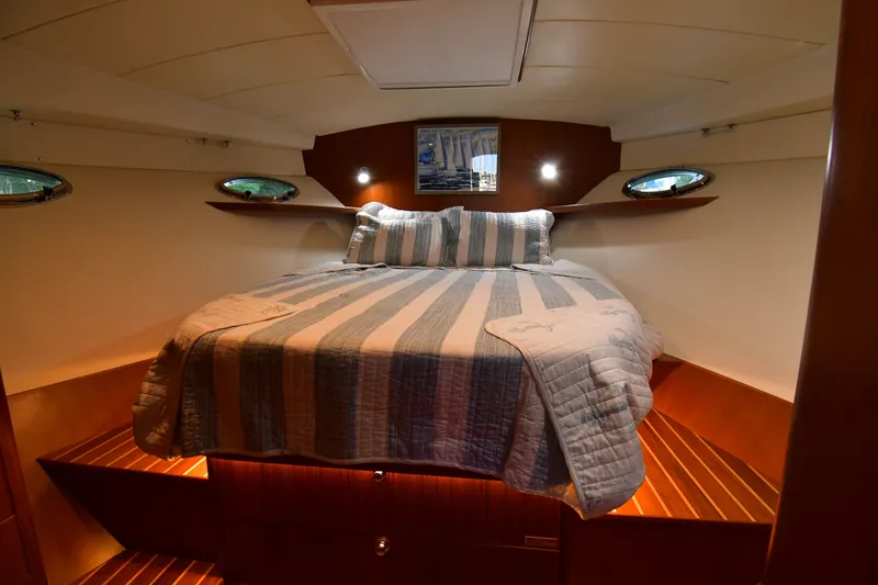 Promesa Yacht Photos Pics Cozy cabin interior of 2021 Hylas M44 yacht with striped bedding and wooden accents.