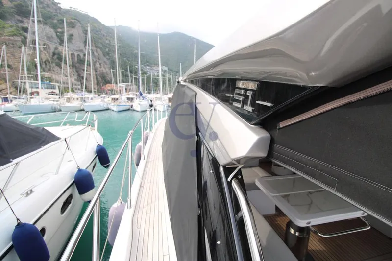  Yacht Photos Pics 2022 Azimut Atlantis 51 yacht docked in a marina with scenic mountain backdrop.