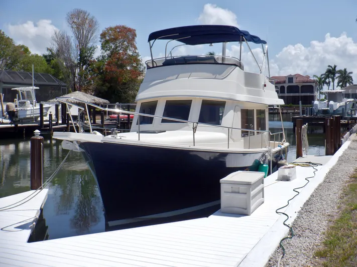 Betty Sue Yacht Photos Pics 2006 Mainship 34 Trawler docked at marina, featuring sleek design and spacious deck.
