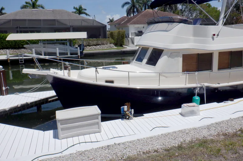 Betty Sue Yacht Photos Pics 2006 Mainship 34 Trawler docked at a marina with waterfront homes.