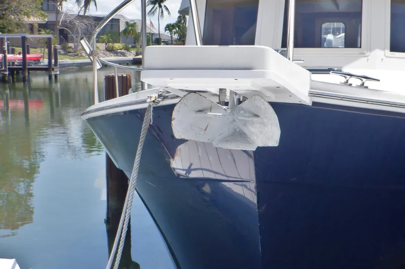 Betty Sue Yacht Photos Pics 2006 Mainship 34 Trawler with anchor, docked in a serene marina setting.