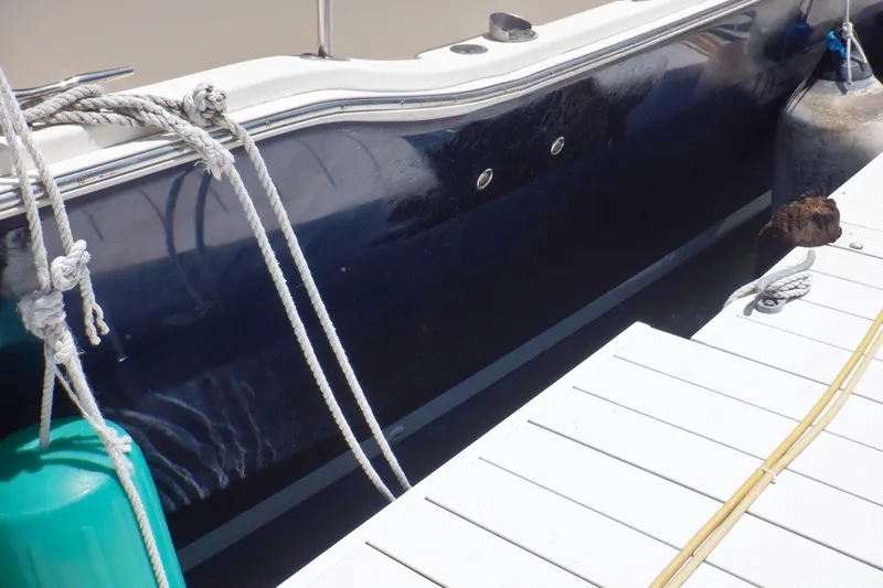 Betty Sue Yacht Photos Pics 2006 Mainship 34 Trawler docked, showing hull and mooring ropes.