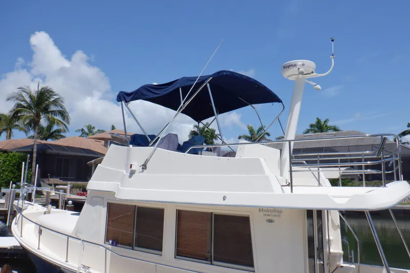 Betty Sue Yacht Photos Pics 2006 Mainship 34 Trawler docked, featuring blue canopy and radar, under clear sky.