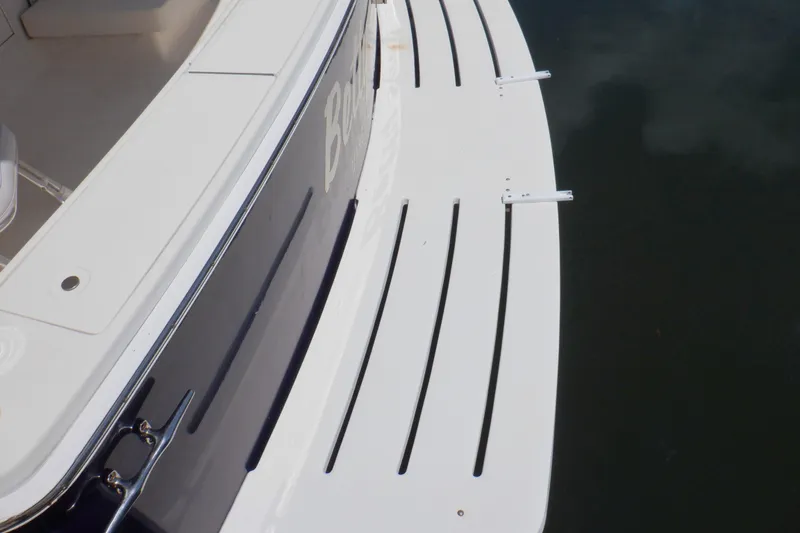 Betty Sue Yacht Photos Pics 2006 Mainship 34 Trawler swim platform with sleek design and water reflection.