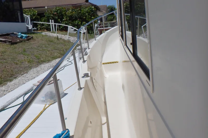 Betty Sue Yacht Photos Pics 2006 Mainship 34 Trawler side deck with railing and window view.