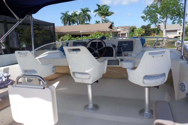 Betty Sue Yacht Photos Pics 2006 Mainship 34 Trawler helm with dual seats, steering wheel, and navigation equipment.