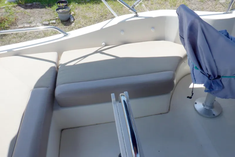Betty Sue Yacht Photos Pics 2006 Mainship 34 Trawler interior seating area with covered chair and railing.