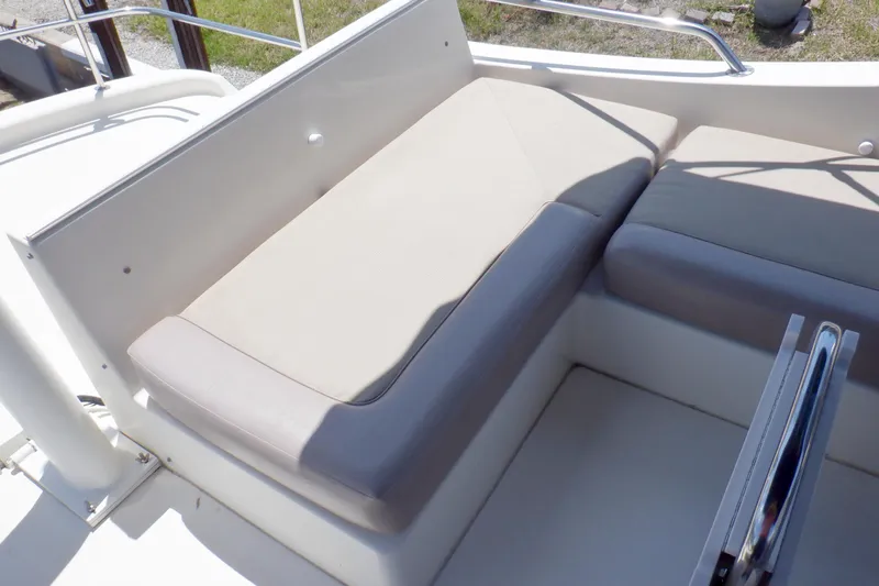 Betty Sue Yacht Photos Pics 2006 Mainship 34 Trawler seating area with cushioned bench and metal railing.