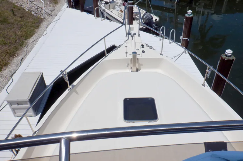 Betty Sue Yacht Photos Pics 2006 Mainship 34 Trawler bow view at dock, featuring deck and railing.