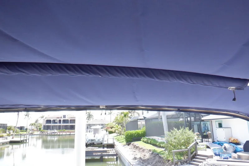 Betty Sue Yacht Photos Pics Blue canopy on 2006 Mainship 34 Trawler, overlooking waterfront property.