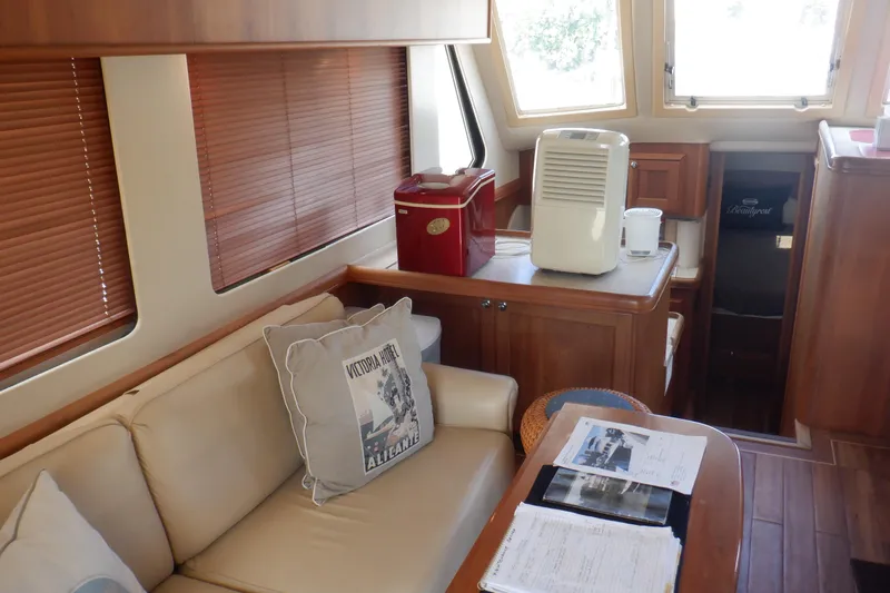 Betty Sue Yacht Photos Pics Interior of 2006 Mainship 34 Trawler with cozy seating and wooden cabinetry.