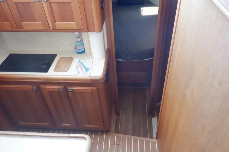 Betty Sue Yacht Photos Pics 2006 Mainship 34 Trawler interior with wooden cabinetry and compact kitchen area.
