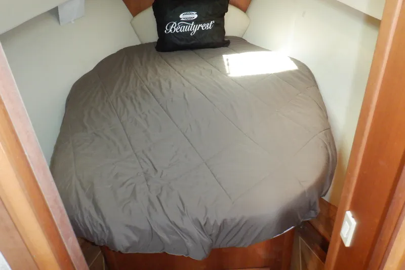 Betty Sue Yacht Photos Pics Cozy cabin bed in 2006 Mainship 34 Trawler with gray bedding and "Beautyrest" pillow.