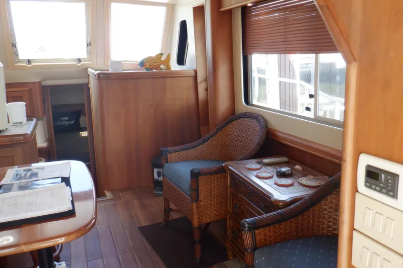 Betty Sue Yacht Photos Pics Interior of 2006 Mainship 34 Trawler with wicker chairs and wooden furnishings.