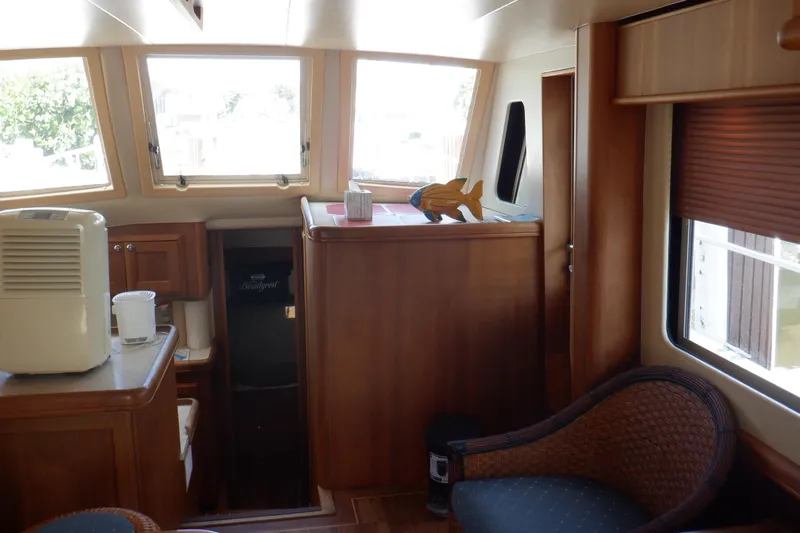 Betty Sue Yacht Photos Pics Interior of 2006 Mainship 34 Trawler with wooden cabinetry and seating area.