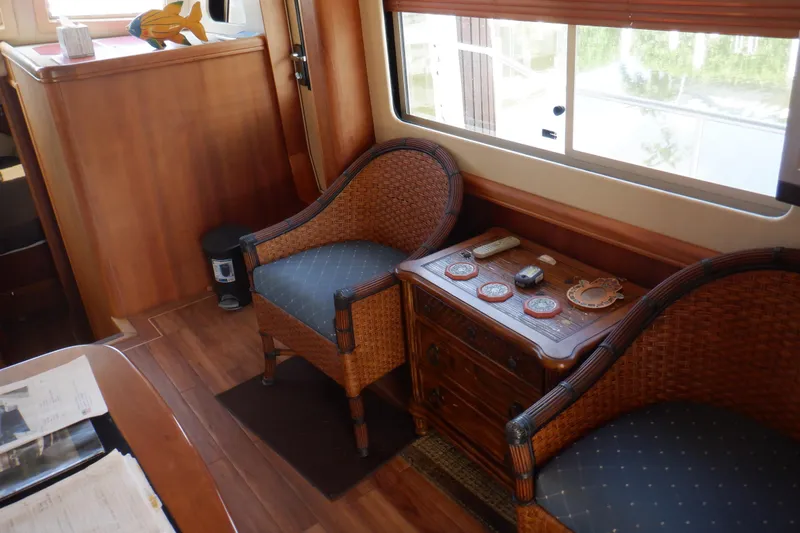 Betty Sue Yacht Photos Pics Interior of 2006 Mainship 34 Trawler with wicker chairs and wooden accents.